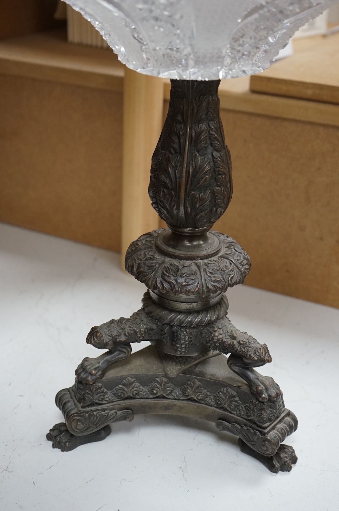 A large cut glass tazza, on bronze tri-form pedestal base, 39cm high.